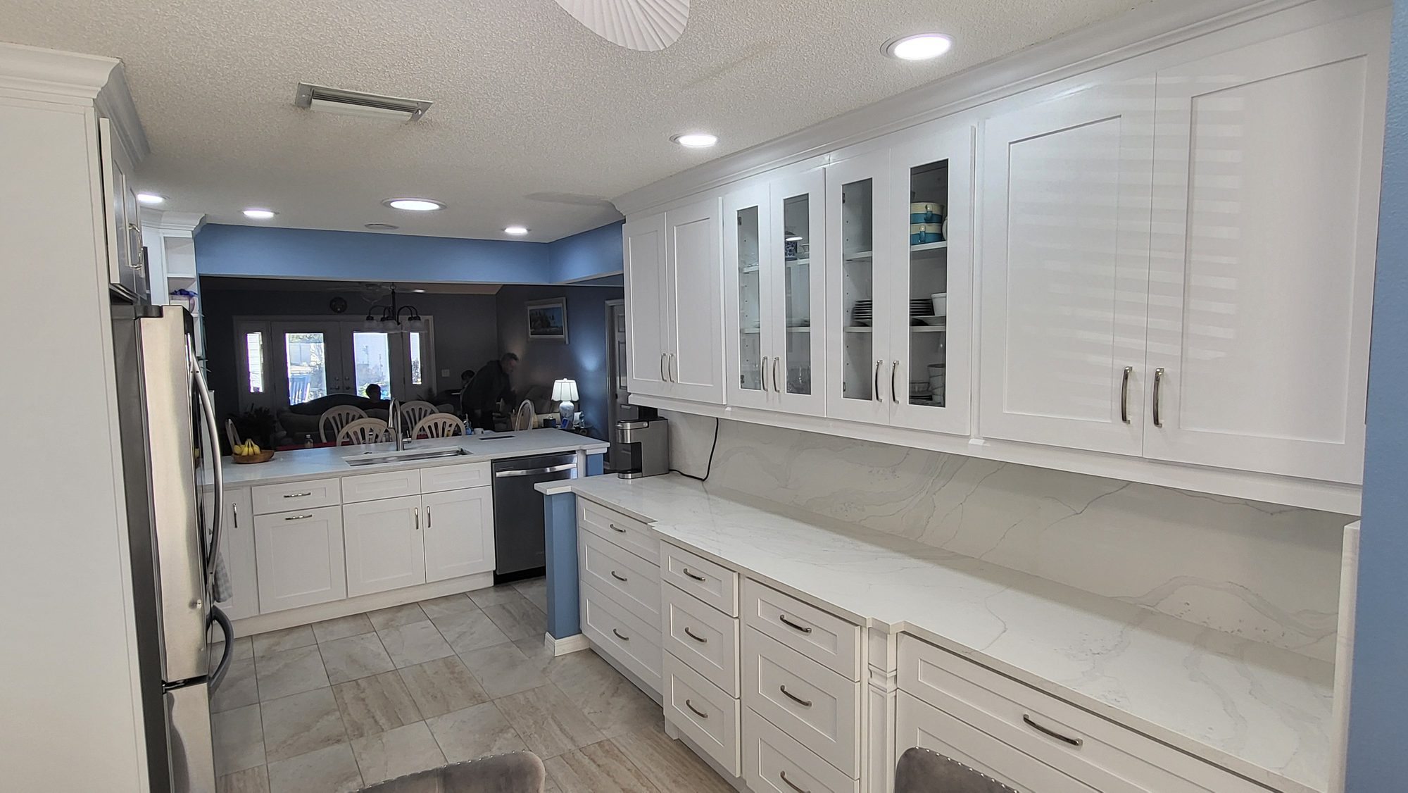 White Kitchen with Louvered Doors and Glass Uppers