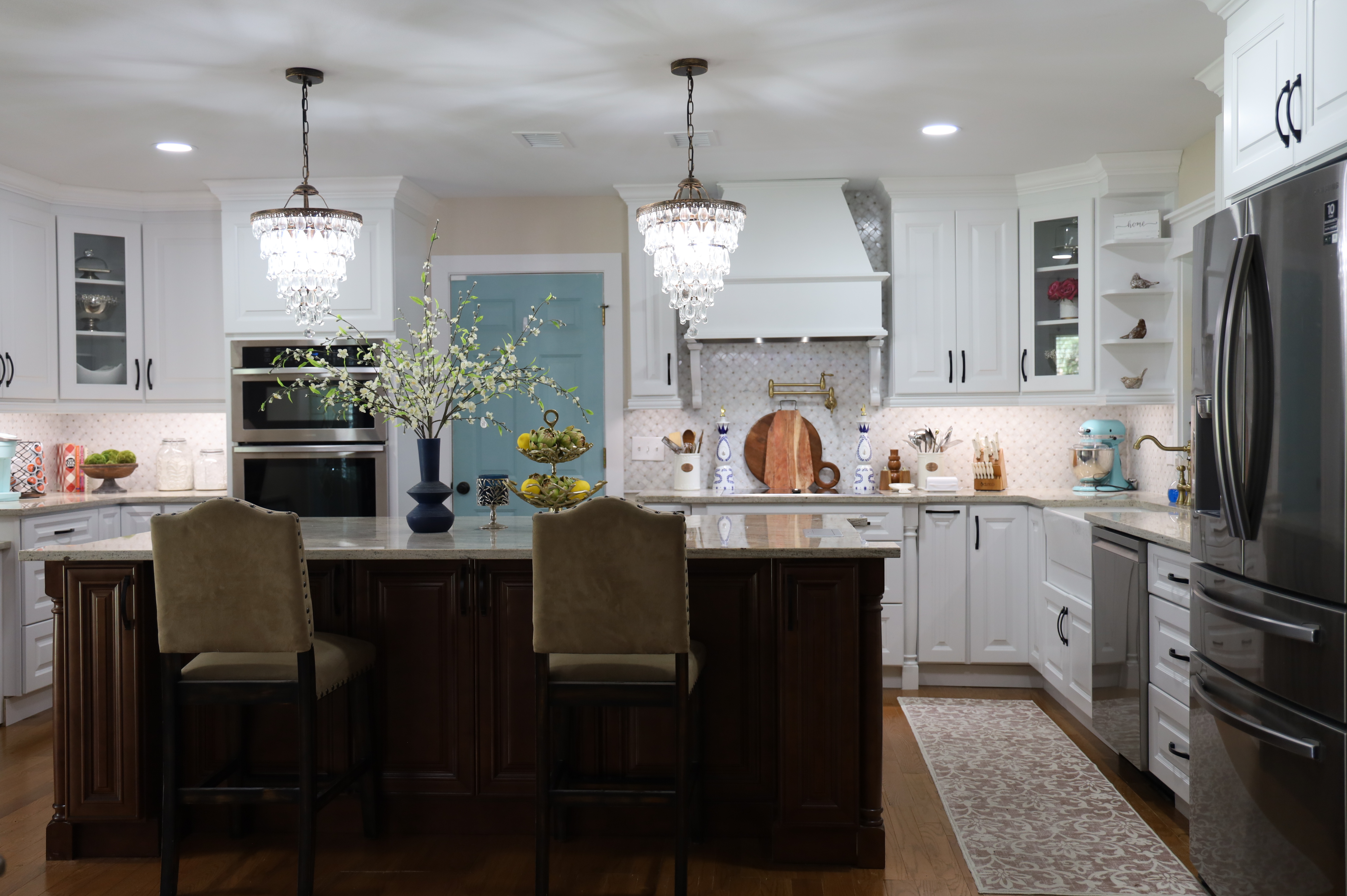 White kitchen cabinets under crystal chandeliers
